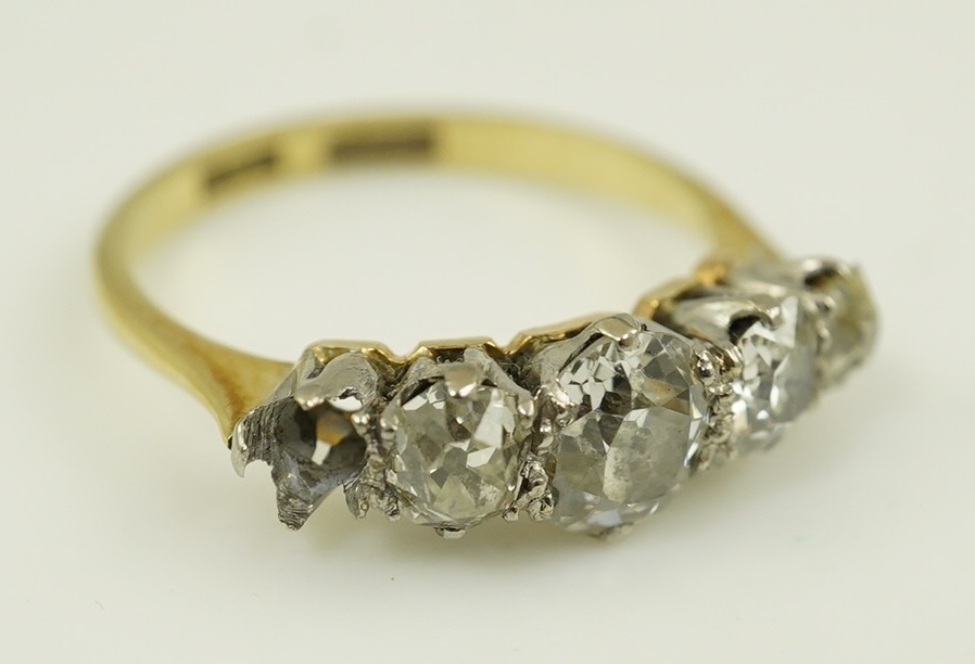 An early 20th century 18ct gold, platinum and graduated five stone old mine cut diamond set half hoop ring(one stone missing)